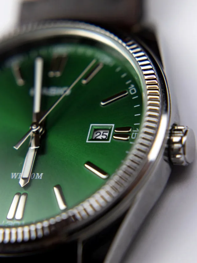 Close-up shot of a wristwatch with a striking green dial, showcasing time precision.