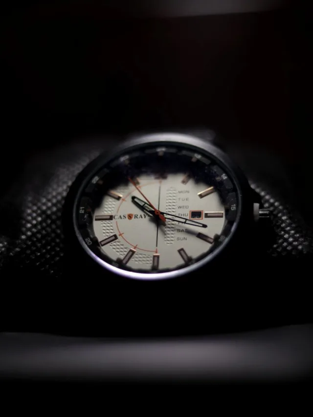 Detailed close-up of a stylish and luxurious wristwatch face with dark background.