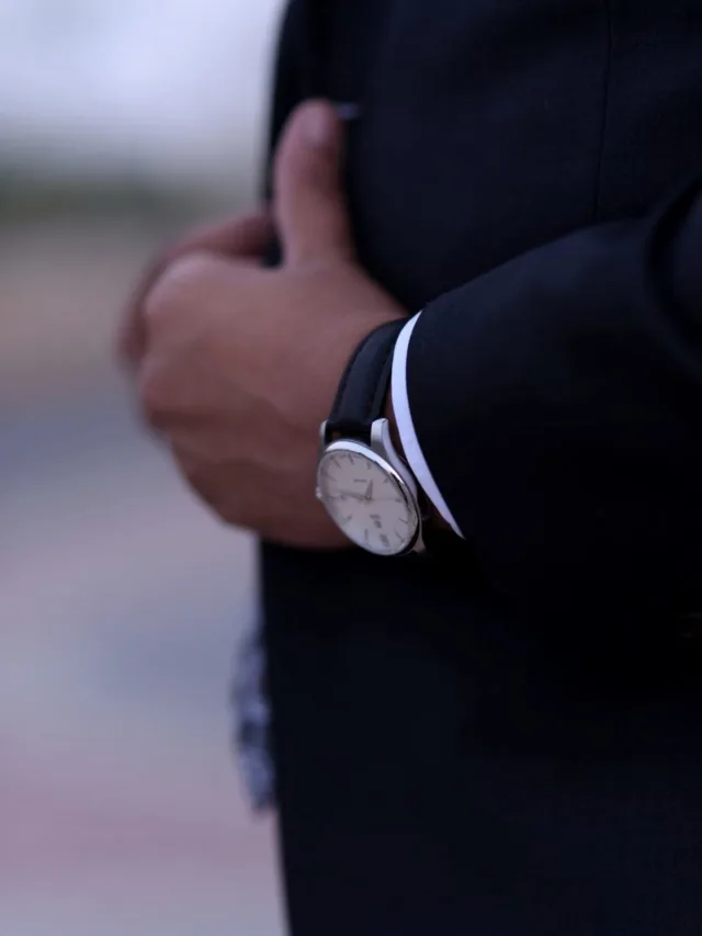 Close-up view of a man's hand wearing a classic wristwatch, showcasing elegance.