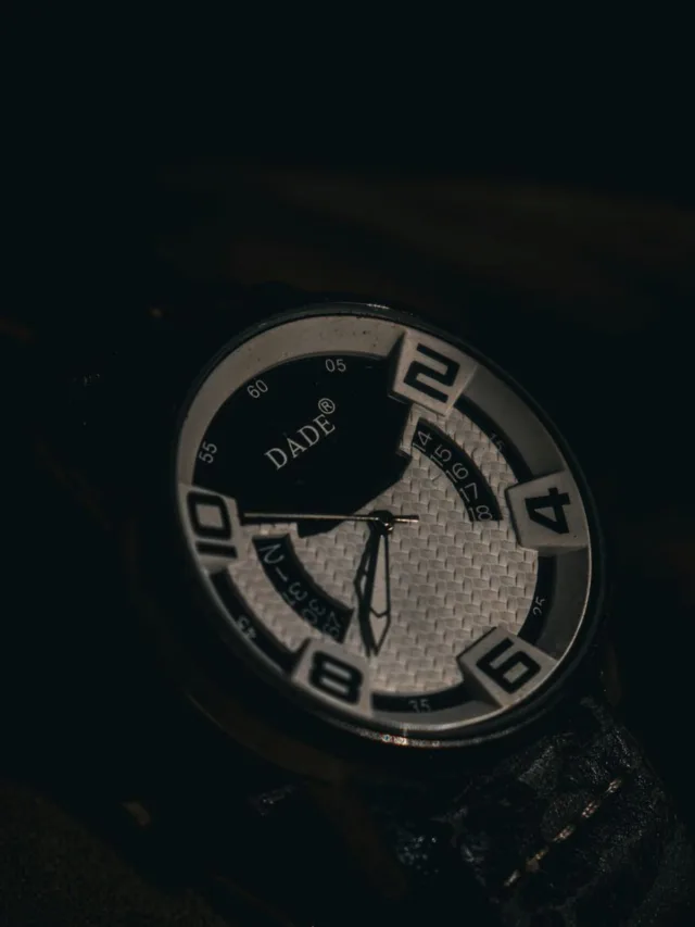 Close-up view of a stylish wristwatch with a dark, moody ambiance.